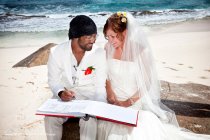Signing wedding register on beach.